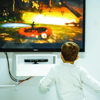Un bambino interagisce con un videogioco con tutto il corpo usando tencologia KinectTM